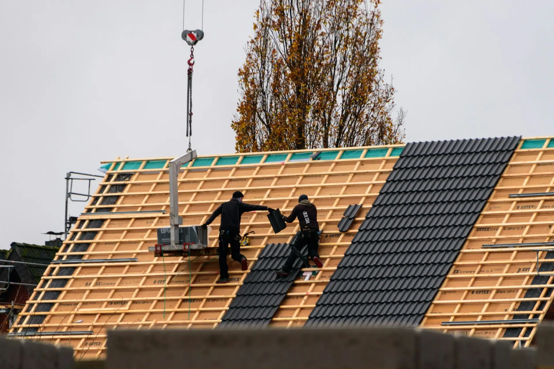 Crew laying new roof tiles on battens