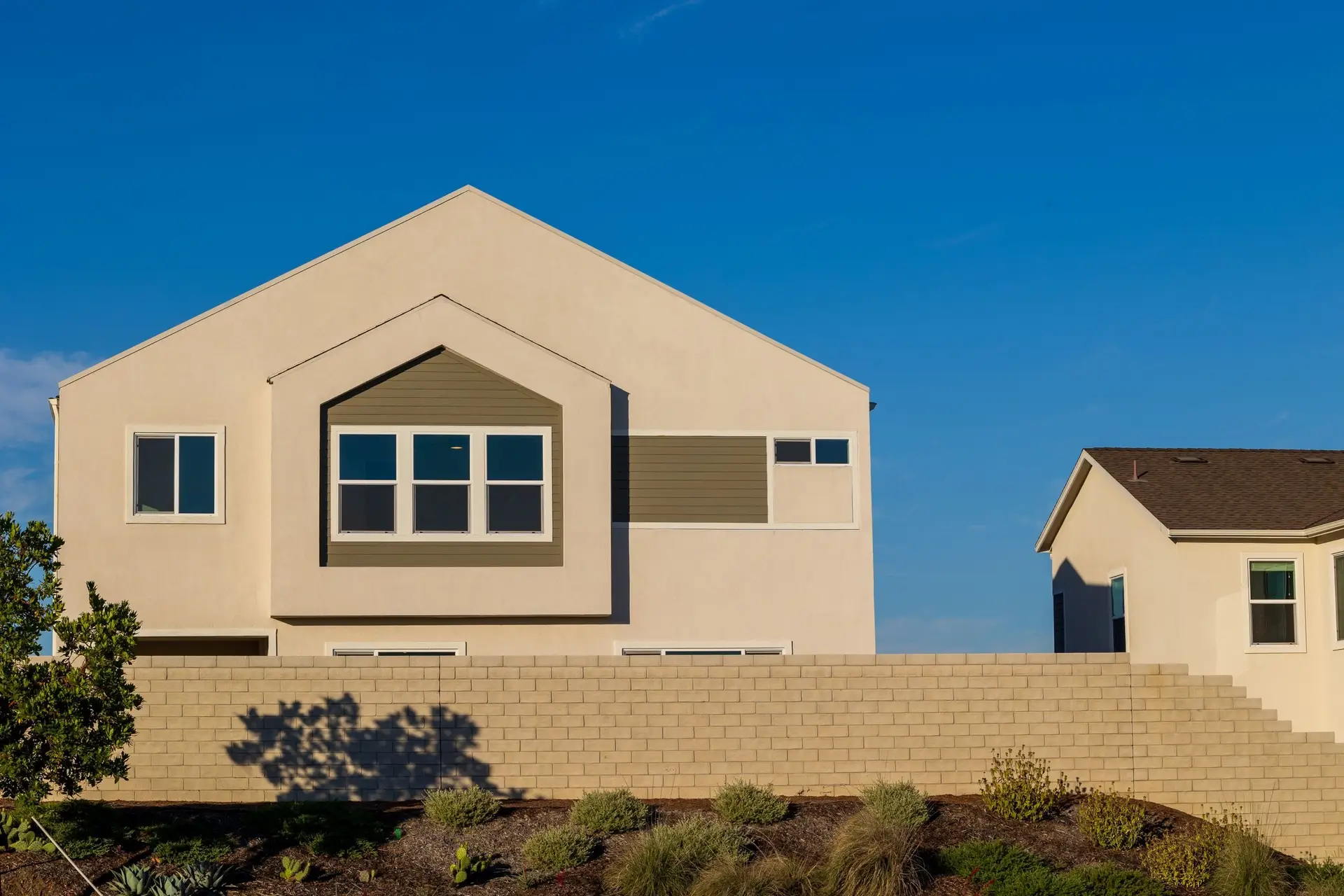 Side of a stucco home under a blue sky