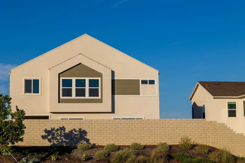 Side of a stucco home under a blue sky