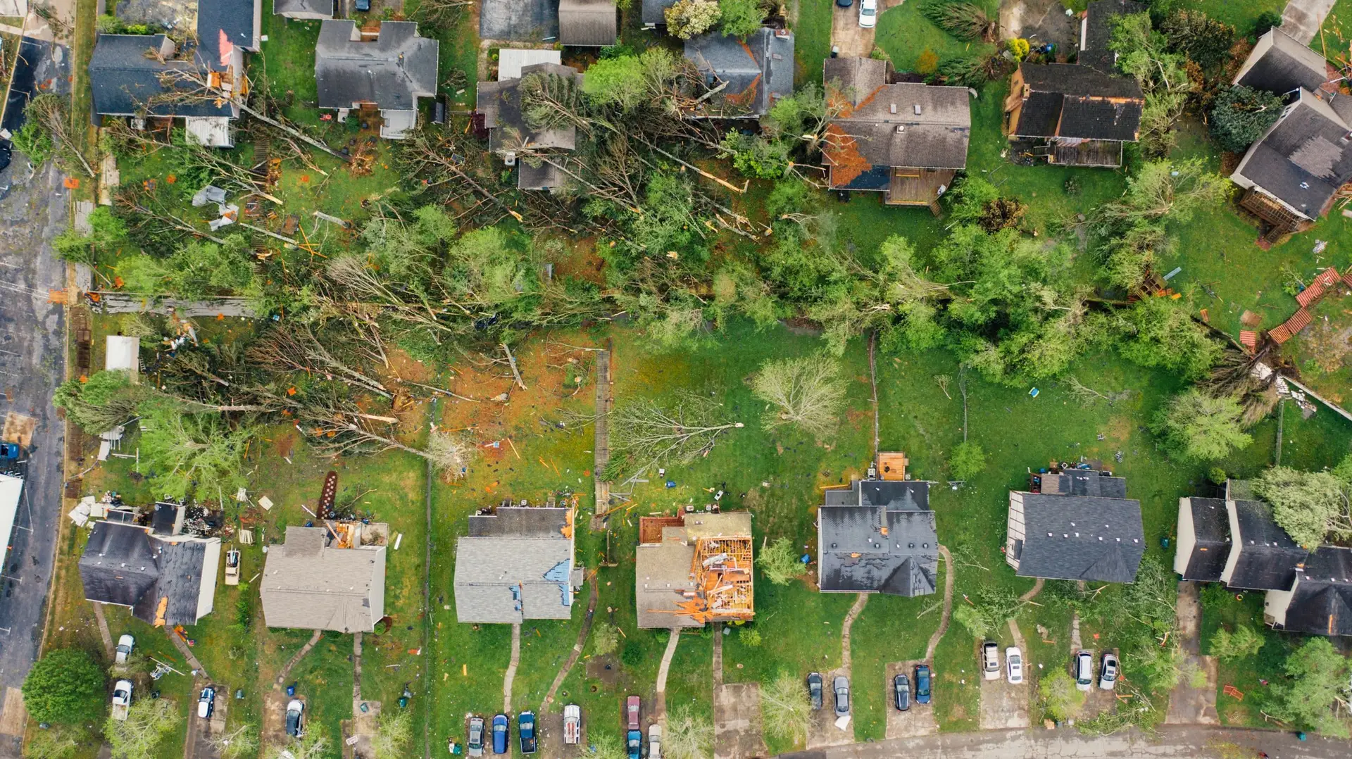 Aerial view of homes with roofs torn open after a storm