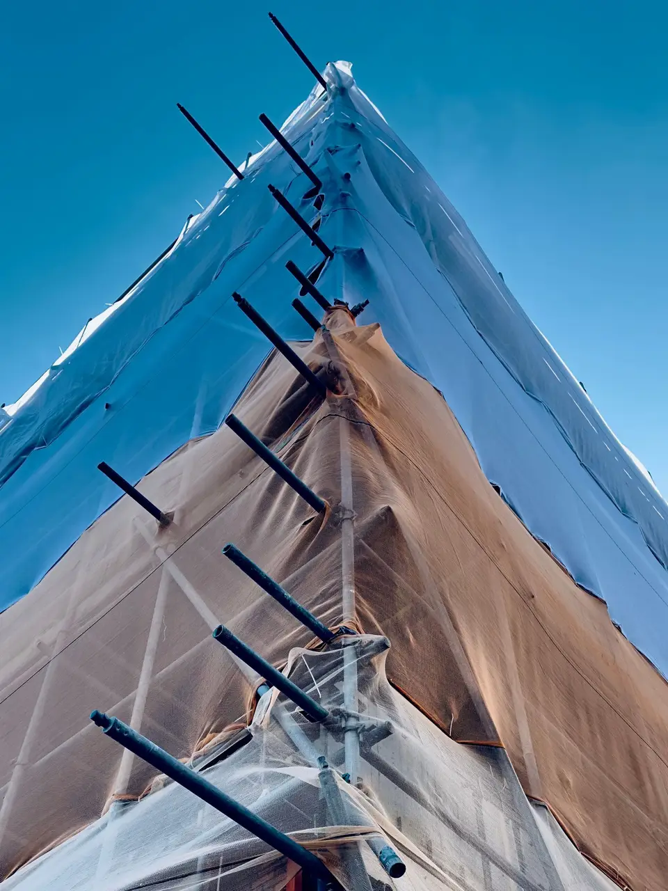 Protective tarp on scaffolding against a blue sky